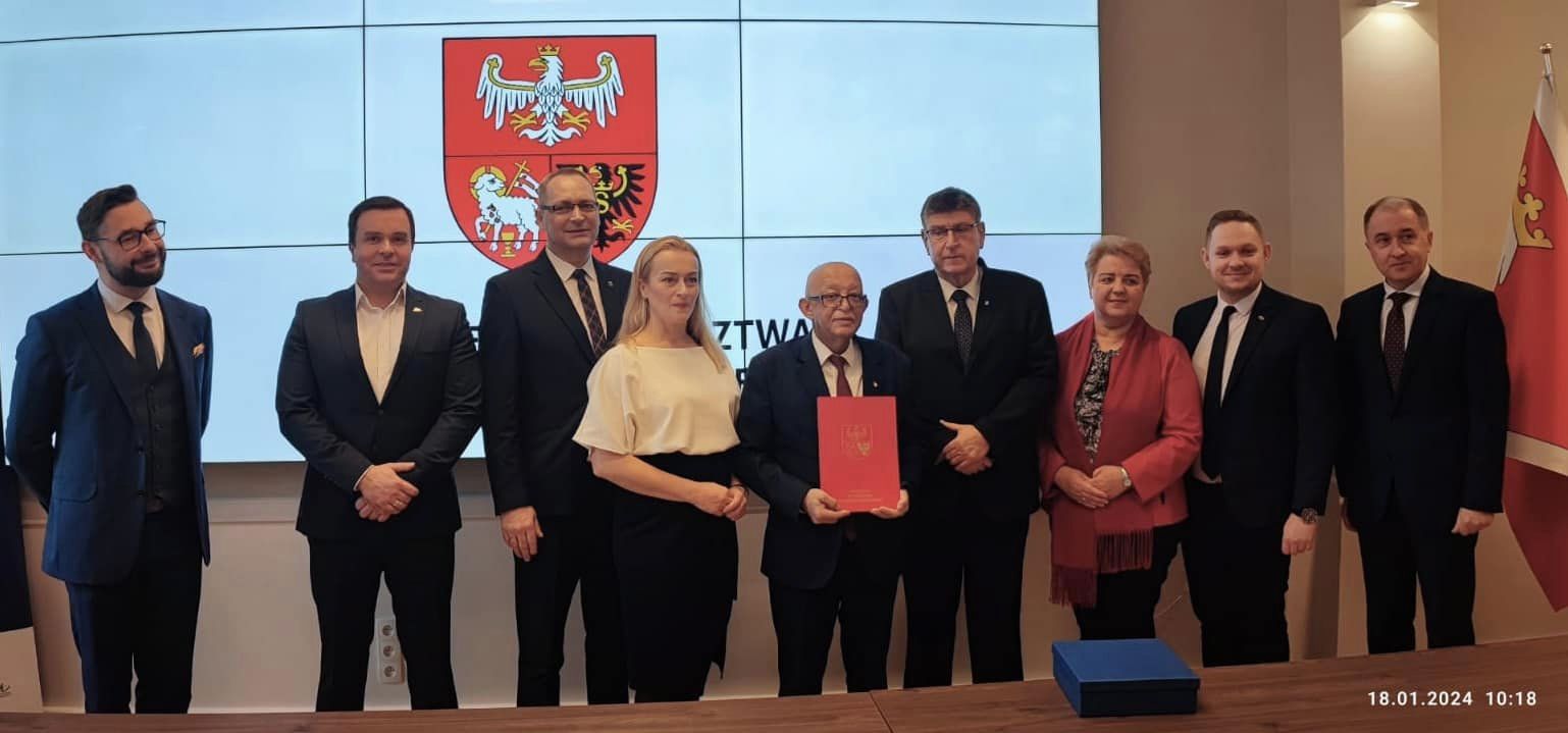 Zdjęcie grupowe, na którego pierwszym planie znajduje się uroczyste podpisane porozumienie terytorialne